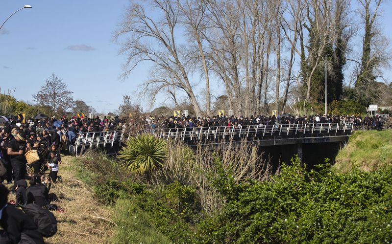 Mourners crowd the roads as the body of Maori king, Kingi Tuheitia, is carried up Taupiri Mountain for burial at Ngaruawahia, New Zealand, Thursday, Sept 6, 2024. (AP Photo/Alan Gibson)