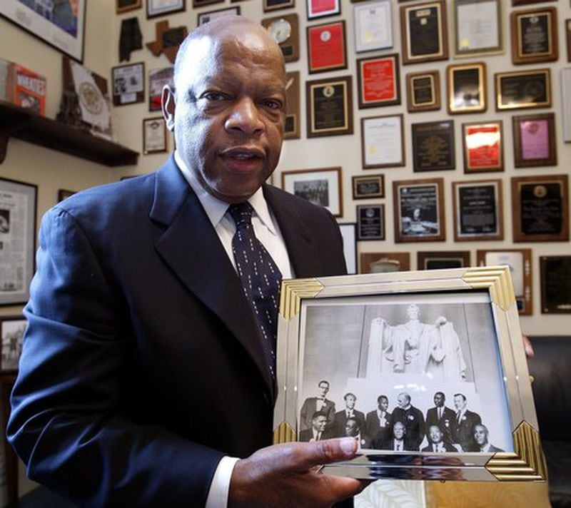 In 2003, Rep. John Lewis, D-Ga., holds one of the many photos from the March on Washington that decorated his Capitol Hill office.  