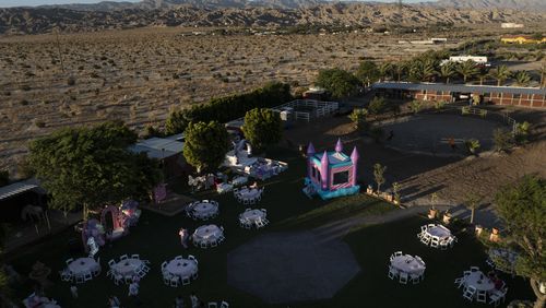 This aerial view shows Carlos Ulloa's Rancho El Refugio date palm ranch decorated for a baptism ceremony in Twentynine Palms, Calif., Saturday, June 15, 2024. Ulloa has come to appreciate date palms after buying land seven years ago in Thousand Palms. (AP Photo/Jae C. Hong)