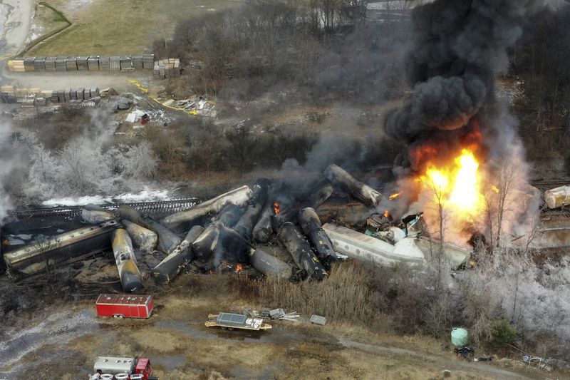 FILE - Portions of a Norfolk Southern freight train that derailed the night before burn in East Palestine, Ohio, Feb. 4, 2023. On Tuesday, April 9, 2024, Days before the National Transportation Safety Board is set to explain why first responders were wrong to blow open five tank cars and burn the toxic chemical inside after the East Palestine derailment, Norfolk Southern said Friday, June 21, 2024 it plans to lead an industrywide effort to improve the way those decisions are made. (AP Photo/Gene J. Puskar, File)