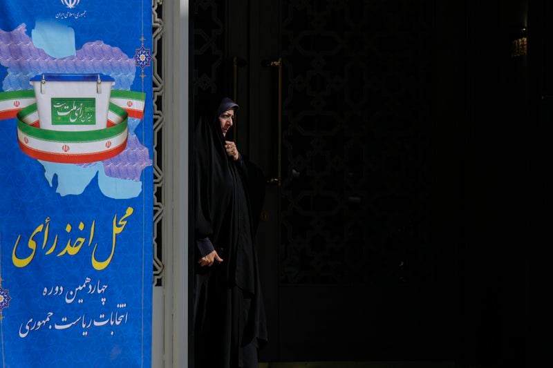 A woman prepares to casts her ballot during the presidential election at a polling station inside the Iranian embassy in Baghdad, Iraq, Friday, June 28, 2024. Iranians are voting in a presidential election to replace the late President Ebrahim Raisi, killed in a helicopter crash in May along with the country's foreign minister and several other officials. (AP Photo/Hadi Mizban)
