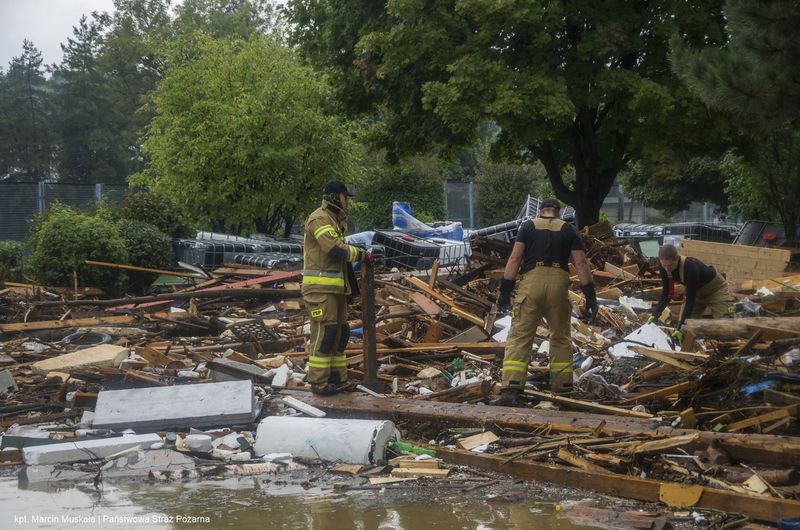 This handout photo provided by the Polish fire department, shows firefighters removing piles of debris dumped in the streets by high flood wave that is passing through southwestern Poland, in Glucholazy, Poland, on Tuesday, Sept. 17, 2024. ( Marcin Muskala/KG PSP via AP)