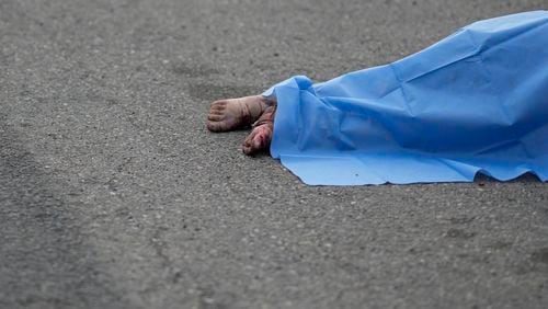 A blue sheet covers a body found lying on the side of a road in Culiacan, Sinaloa state, Mexico, Saturday, Sept. 21, 2024. (AP Photo/Eduardo Verdugo)