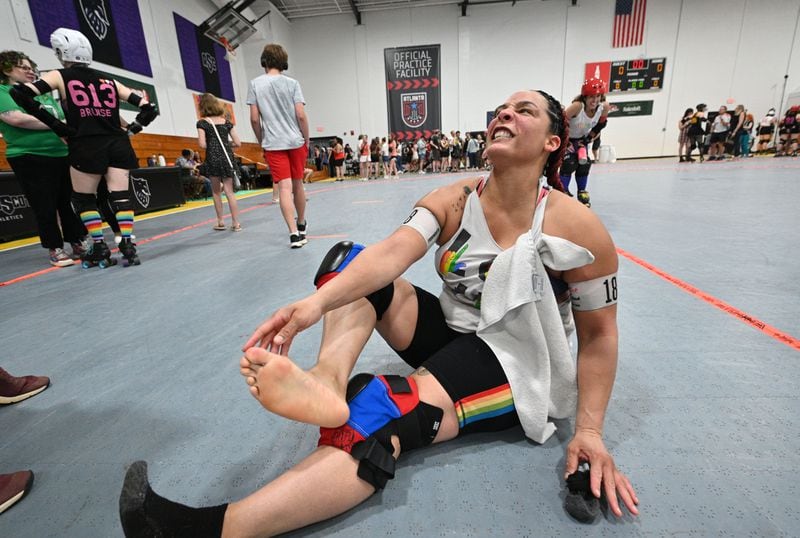 Samantha Flowers, a.k.a ThumpHER, takes off socks in pain after Atlanta Roller Derby game at Agnes Scott College’s Woodruff Athletic Complex, Saturday, June 8, 2024, in Decatur. (Hyosub Shin / AJC)