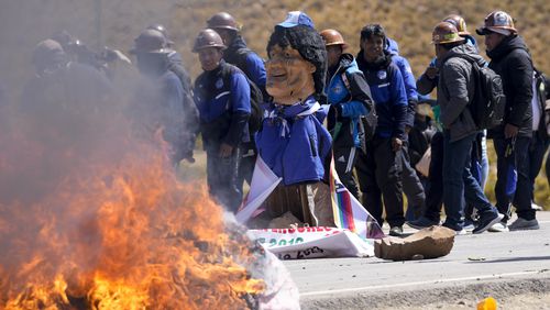 An effigy of former President Evo Morales burns on a road in Vila Vila, Bolivia, to block Morales supporters who are marching to the capital to protest the government of current President Luis Arce in an escalation of a political dispute between the two politicians, Tuesday, Sept. 17, 2024. (AP Photo/Juan Karita)