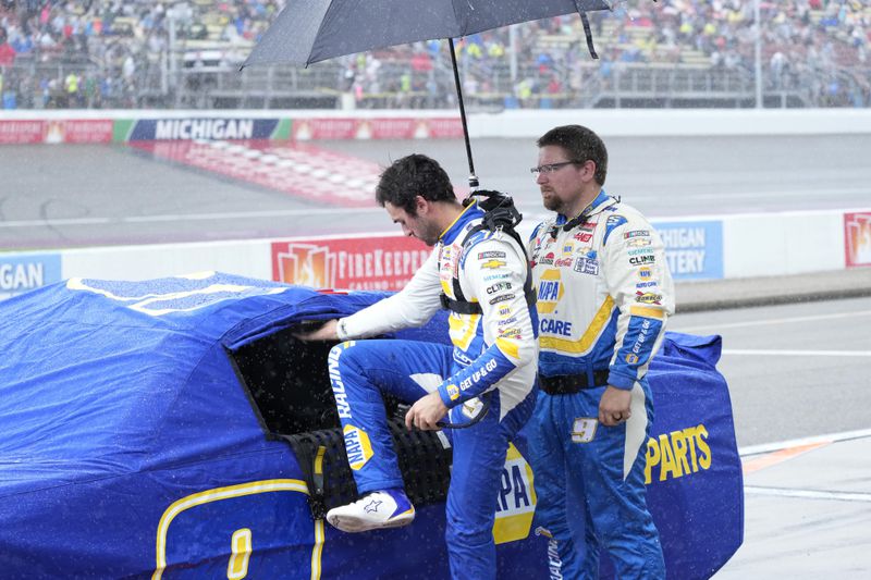 Chase Elliott exits his car during a rain delay of a NASCAR Cup Series auto race at Michigan International Speedway, Sunday, Aug. 18, 2024, in Brooklyn, Mich. (AP Photo/Carlos Osorio)