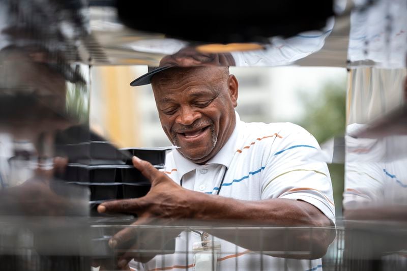 Meals on Wheels employee Napier Williams loads hot meals into a special warming section of a Meals on Wheels delivery truck, Friday, July 12, 2024, in Houston. (AP Photo/Annie Mulligan)