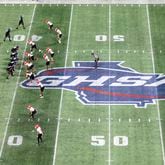 The Cedar Grove offense prepares for a play against the Savannah Christian defense near the GHSA logo at midfield during the Class 3A GHSA State Championship game at Mercedes-Benz Stadium, Wednesday, December. 13, 2023, in Atlanta. (Jason Getz / Jason.Getz@ajc.com)