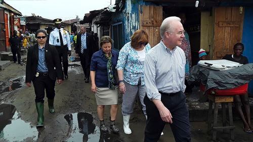 US Secretary of Health and Human Services Tom Price, right, walks Thursday May 18, 2017 through a densely-populated and heavily congested Monrovia, Liberia, slum community which was quarantined in 2014 when Ebola struck there killing dozens. This is Price's first visit outside the US since assuming the position. (AP Photo/Jonathan Paye-Layleh)