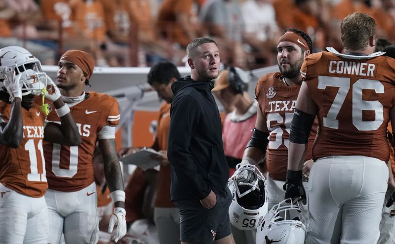 Texas quarterback Quinn Ewers, center, stands on the sidelines in street cloths after he was injured during the second half of an NCAA college football game against UTSA in Austin, Texas, Saturday, Sept. 14, 2024. (AP Photo/Eric Gay)