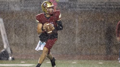 While rain pours down, Johns Creek quarterback Michael McClellan (12) attempts a pass during their game against Parkview at Johns Creek high school Wednesday, Aug. 17, 2022, in Johns Creek, Ga. Parkview won 52-7. (Jason Getz/AJC)