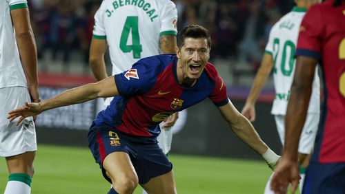 Barcelona's Robert Lewandowski, center, celebrates with Barcelona's Jules Kounde, front, after scoring the opening goal during a Spanish La Liga soccer match between Barcelona and Getafe at the Olympic stadium in Barcelona, Spain, Wednesday, Sept. 25, 2024. (AP Photo/Joan Monfort)