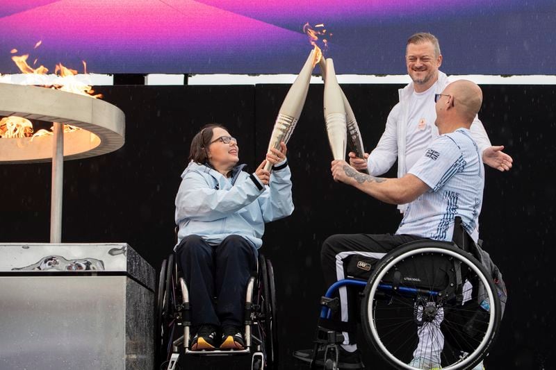 British Paralympians Helene Raynsford and Gregor Ewan light the Paralympic Flame in Stoke Mandeville, widely considered the birthplace of the Paralympic Games, England, Saturday, Aug. 24, 2024. (AP Photo/Thomas Krych)