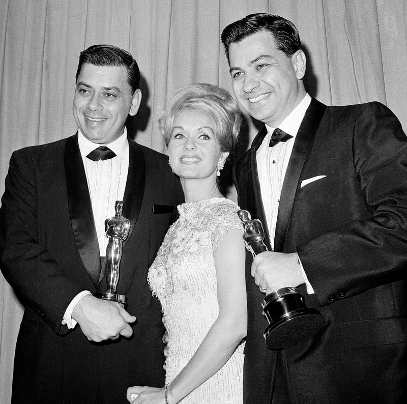 FILE - Actress Debbie Reynolds poses with Academy Awards winners for best music Richard M. Sherman, right, and Robert Sherman, left, who received the award for "Mary Poppins" in Santa Monica, Calif., April 5, 1965. Richard Sherman, one half of the prolific, award-winning pair of brothers who helped form millions of childhoods by penning classic Disney tunes, died Saturday, May 25, 2024. He was 95. (AP Photo/File)