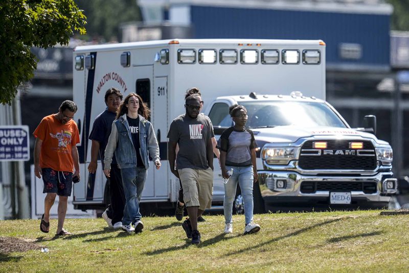 Students and parents walk off campus at Apalachee High School, Wednesday, Sept. 4, 2024, in Winder, Ga. A shooting at the Georgia high school Wednesday caused an unknown number of injuries and a suspect was arrested in a chaotic scene. (AP Photo/Mike Stewart)