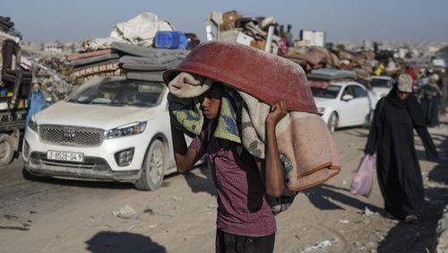 A Palestinian youth flees the Khan Younis area of the Gaza Strip, following Israeli military evacuation orders, saying its forces will soon operate there, Thursday, Aug. 8, 2024. (AP Photo/Abdel Kareem Hana)