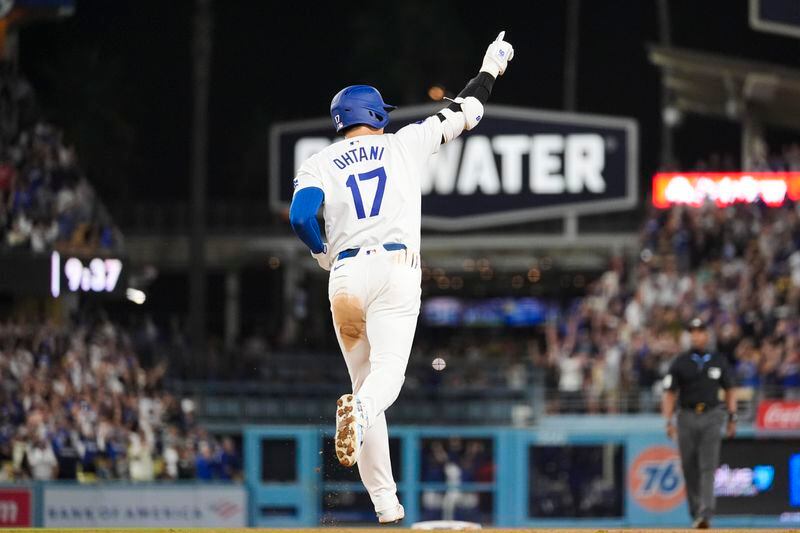 Los Angeles Dodgers designated hitter Shohei Ohtani (17) runs the bases after hitting a grand slam during the ninth inning of a baseball game against the Tampa Bay Rays in Los Angeles, Friday, Aug. 23, 2024. The Dodgers won 7-3. Will Smith, Tommy Edman, and Max Muncy also scored. (AP Photo/Ashley Landis)