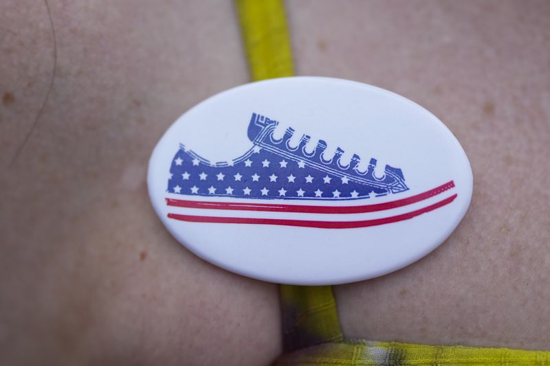 Illinois Rep. Kelly Cassidy wears a pin as she talks with visitors to the Glenwood Avenue Arts Festival about canvassing efforts for the Democratic Party, Monday, Aug. 26, 2024, in Chicago. (AP Photo/Erin Hooley)