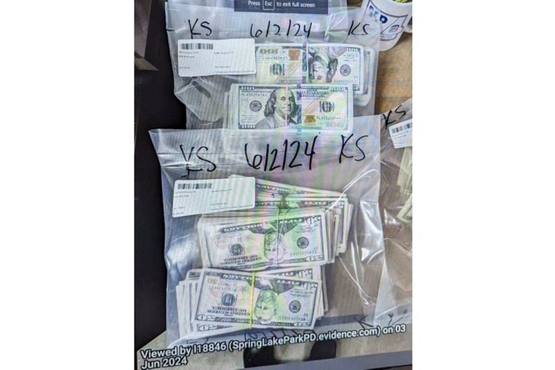 This photo supplied by the U.S. Attorney's Office for Minnesota shows cash from a bag that was left at the home of a juror in a massive fraud case, June 2, 2024, outside Minneapolis, Minn. Authorities have confiscated cellphones and taken all seven defendants into custody as investigators try to determine who attempted to bribe the juror to acquit them on charges of stealing more than $40 million from a program meant to feed children during the pandemic. (U.S. Attorney's Office for Minnesota via AP)