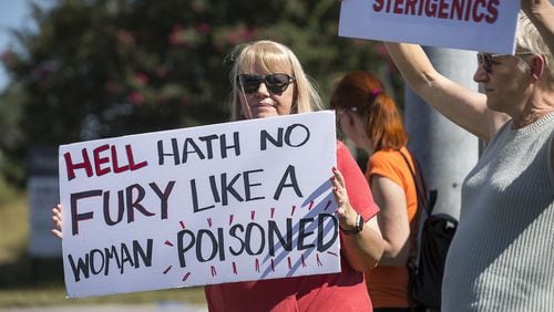 Jenni Shover of Smyrna (center) holds a sign during a protest against a Cobb County Sterigenics plant at the intersection of Atlanta Road and Plant Atkinson Road, Thursday, August 29, 2019. (Alyssa Pointer/alyssa.pointer@ajc.com)