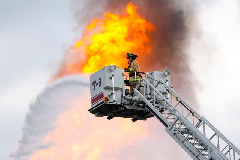 A firefighter directs a line of water around a fire on a pipeline carrying liquified natural gas near Spencer Highway and Summerton on Monday, Sept. 16, 2024, in La Porte, Texas. (Brett Coomer/Houston Chronicle via AP)