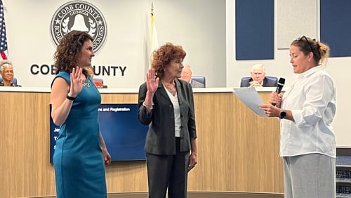 Stacy Efrat (left) and Debbie Fisher (center) are sworn in to serve on the Cobb County Board of Elections by Chief Judge Kelli Wolk (right) on Thursday, June 29, 2023. (Taylor Croft/taylor.croft@ajc..com)