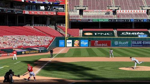 FILE - Cincinnati Reds' Jesse Winker, left, hits a single of a pitch thrown by Chicago White Sox' Garrett Crochet, right, during a baseball game in Cincinnati, Sunday, Sept. 20, 2020. (AP Photo/Aaron Doster, File)