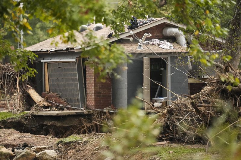 A building is damaged as water rushed over the roof in the aftermath of Hurricane Helene, Tuesday, Oct. 1, 2024, in Swannanoa, N.C. (AP Photo/Mike Stewart)