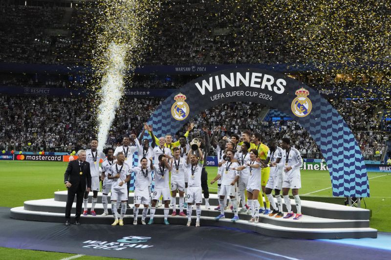 Real Madrid's team members celebrate with the trophy as they won the UEFA Super Cup Final soccer match between Real Madrid and Atalanta at the Narodowy stadium in Warsaw, Poland, Wednesday, Aug. 14, 2024. (AP Photo/Czarek Sokolowski)