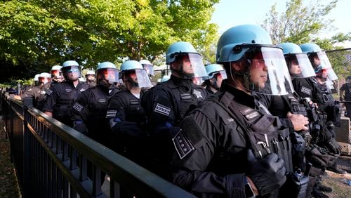 Police line up after a piece of fence was knocked down by protesters surrounding the United Center at the Democratic National Convention Monday, Aug. 19, 2024, in Chicago. (AP Photo/Alex Brandon)