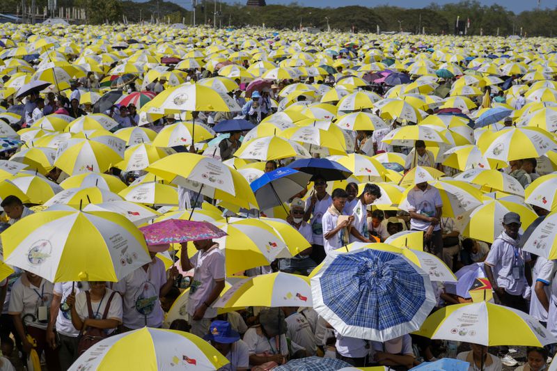 Faithful use umbrellas with the colors of the Vatican flag to shield themselves from the sun as they wait for a mass presided over by Pope Francis to start in Tasitolu, some 8 kilometers west of Dili, East Timor, Tuesday, Sept. 10, 2024. Pope Francis presides over a mass in a seaside park on the same field where St. John Paul II celebrated a historic liturgy during East Timor's fight for independence from Indonesian rule. (AP Photo/Gregorio Borgia)