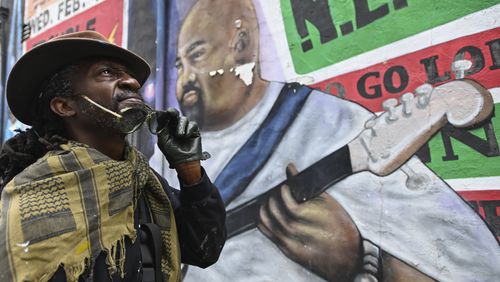 Mural artist Eric B. Ricks poses for a portrait in front of a mural that he oversaw and instructed young artist to paint in 2017 , Monday, Sept. 16, 2024, in Washington. (AP Photo/John McDonnell)