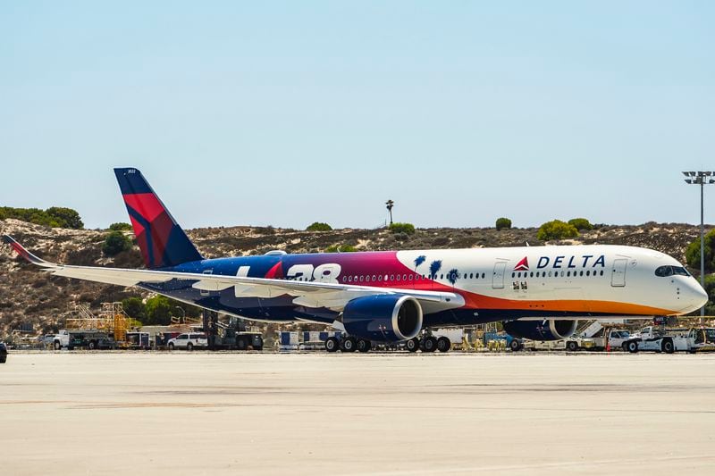 A Delta Air Lines Airbus A330-900 Neo flight DL 291 taxies at Los Angeles International Airport carrying the official Olympic flag on Monday, Aug.12, 2024 in Los Angeles. (AP Photo/Damian Dovarganes)