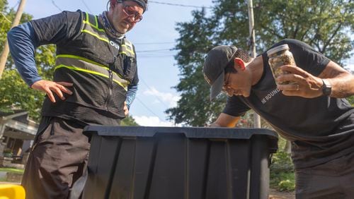 Deliverer Nick McCormack, left, and The Rounds CEO Alex Torrey, right, look through items in a container after McCormack dropped off his delivery on Aug. 2, 2023 in Atlanta. The Rounds, launched in 2019, offers delivery service with zero waste by refilling empty containers. (Michael Blackshire/Michael.blackshire@ajc.com)