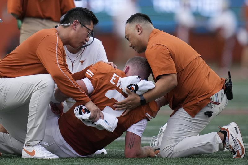 Texas quarterback Quinn Ewers is helped off the field after an injury during the first half of an NCAA college football game against UTSA in Austin, Texas, Saturday, Sept. 14, 2024. (AP Photo/Eric Gay)