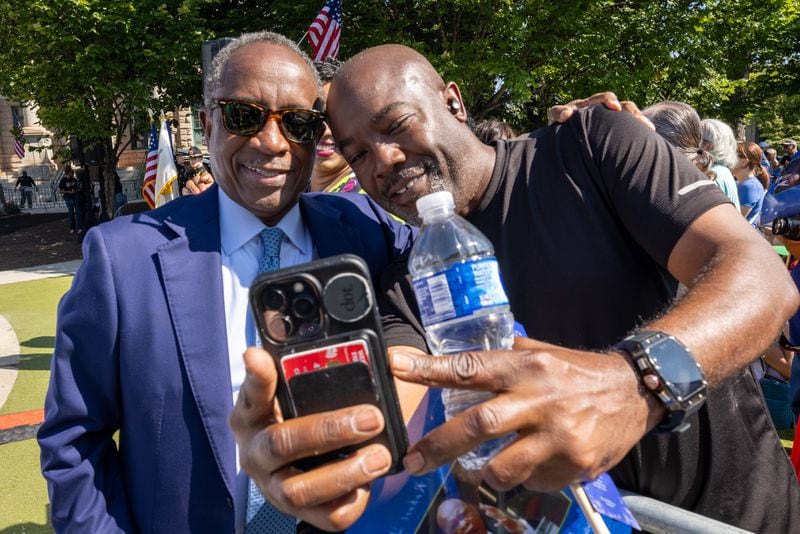 DeKalb CEO Michael Thurmond (Left)  poses for a picture with a crowd member before the statue unveiling ceremony honoring the late Congressman John Lewis in Decatur on Saturday, Aug 24, 2024.