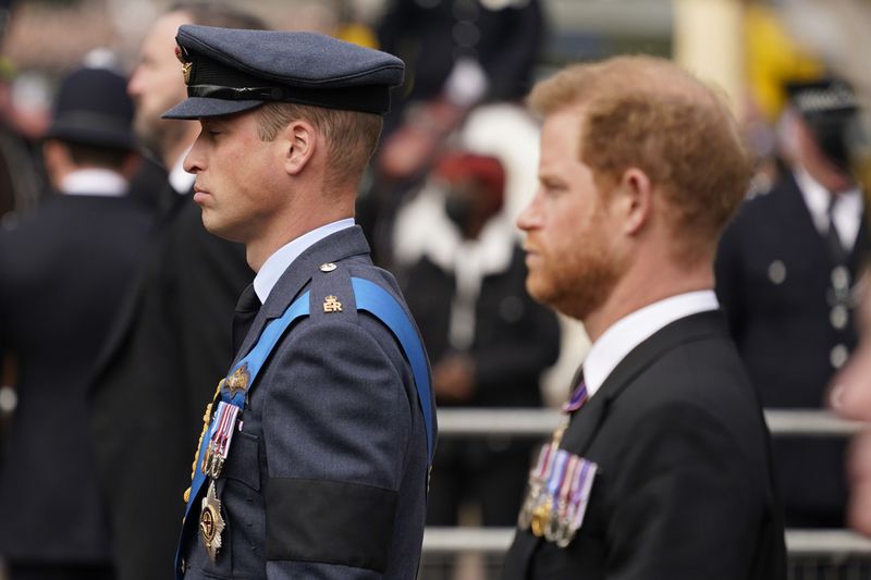 FILE - Prince William, center, and Prince Harry, right, walk behind the coffin of Queen Elizabeth II being pulled past Buckingham Palace following her funeral service at Westminster Abbey in central London, on Sept. 19, 2022. (AP Photo/Alberto Pezzali, File)