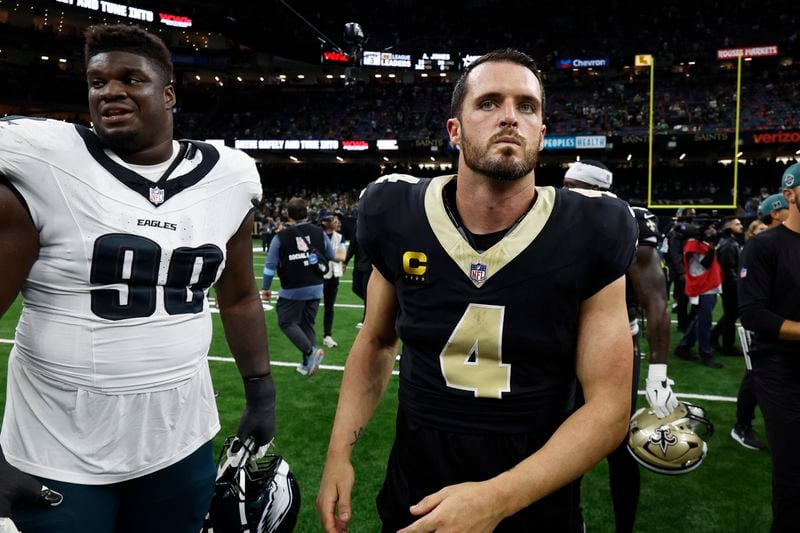 New Orleans Saints quarterback Derek Carr (4) and Philadelphia Eagles defensive tackle Jordan Davis (90) leave the field after an NFL football game in New Orleans, Sunday, Sept. 22, 2024. (AP Photo/Butch Dill)