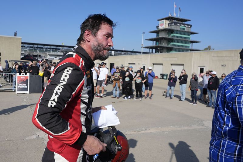 Keanu Reeves walks in the garage area following a GR Cup Series auto race at Indianapolis Motor Speedway, Saturday, Oct. 5, 2024, in Indianapolis. (AP Photo/Darron Cummings)