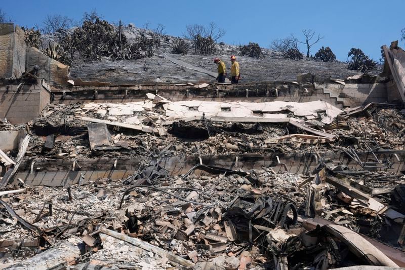 Fire crews examine a property damaged by the Airport Fire Thursday, Sept. 12, 2024, in El Cariso Village, in unincorporated Riverside County, Calif. (AP Photo/Gregory Bull)