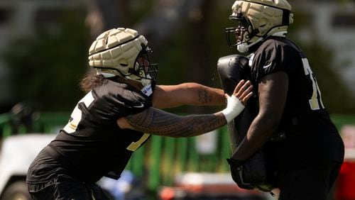 New Orleans Saints offensive tackle Taliese Fuaga, left works on a drill during NFL football training camp, Friday, July 26, 2024, in Irvine, Calif. (AP Photo/Kyusung Gong)