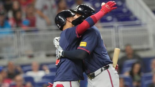 Atlanta Braves' Gio Urshela is hugged by Orlando Arcia after Urshela hit a two-run home run during the seventh inning of a baseball game against the Miami Marlins, Saturday, Sept. 21, 2024, in Miami. (AP Photo/Marta Lavandier)