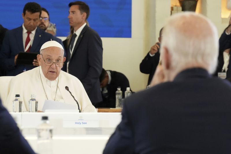 Pope Francis speaks during a working session on Artificial Intelligence (AI), Energy, Africa-Mediterranean, on day two of the 50th G7 summit at Borgo Egnazia, southern Italy, on Friday, June 14, 2024. U.S. President Joe Biden is seen with back to camera. (Christopher Furlong/Pool Photo via AP)