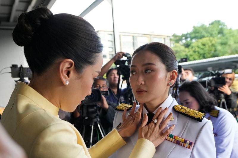 Pinthongta Shinawatra, left, adjusts a tie of her younger sister and Thailand's newly elected Prime Minister Paetongtarn Shinawatra before the royal endorsement ceremony appointing Paetongtarn as Thailand's new prime minister at Pheu Thai party headquarters in Bangkok Sunday, Aug. 18, 2024. (AP Photo/Sakchai Lalit)