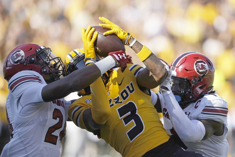 FILE - Missouri wide receiver Luther Burden III (3) catches a pass for a touchdown as South Carolina defensive backs Jalon Kilgore (24) and DQ Smith (1) defend during the first half of an NCAA college football game, Saturday, Oct. 21, 2023 in Columbia, Mo. (AP Photo/Colin E Braley, File)