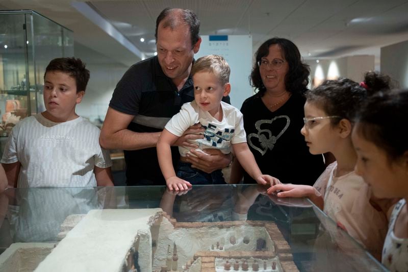 Ariel Heller, 4, center, and his parents Anna, right, and Alex, center left, take part in a special tour after the child accidentally broke an ancient jar at the Reuben and Edith Hecht Museum in Haifa, Israel, Friday, Aug. 30, 2024. The boy who accidentally broke a rare 3,500-year-old jar in an Israeli museum has been forgiven and invited back, as curators hope to turn the disaster into a teachable moment. (AP Photo/Maya Alleruzzo)