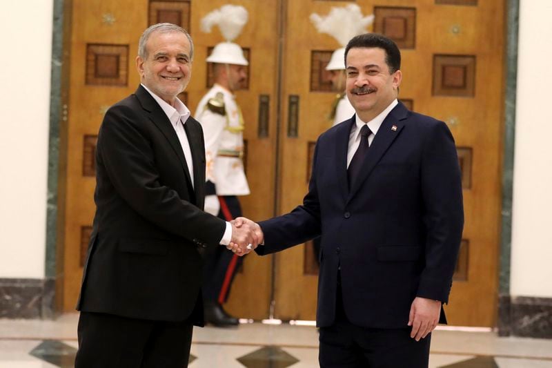 Iranian President Masoud Pezeshkian, left, and Iraqi Prime Minister Mohammed Shia al-Sudani shake hands at the government palace in Baghdad, Iraq, Wednesday, Sept. 11, 2024. (Ahmed Jalil/Pool Photo via AP)