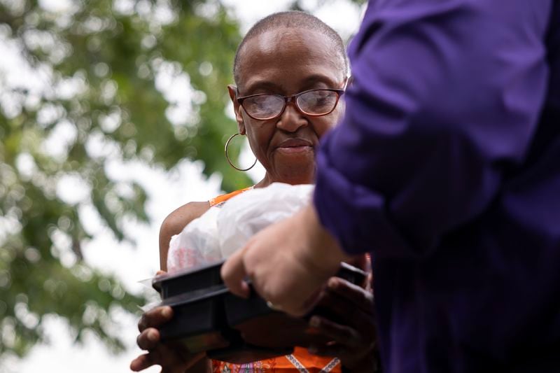 Meals on Wheels client Annie Jones receives a delivery from Meals on Wheels Director of Operations Matthew Wright, Friday, July 12, 2024, in Houston. (AP Photo/Annie Mulligan)