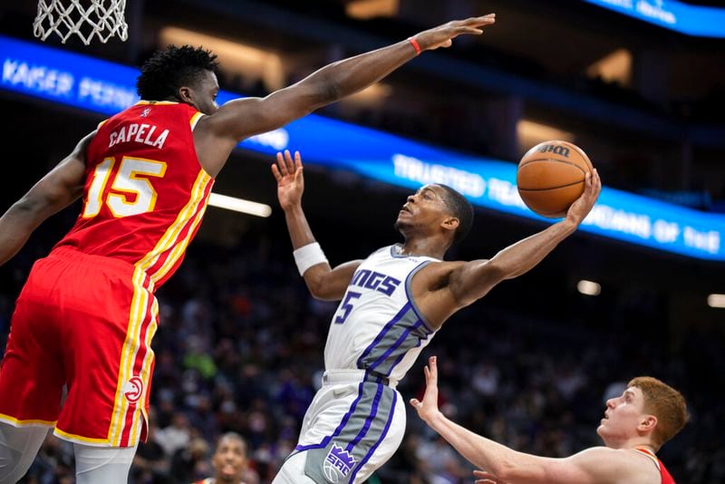 Atlanta Hawks center Clint Capela (15) defends against Sacramento Kings guard De'Aaron Fox (5) on a drive to the basket during the second half of an NBA basketball game in Sacramento, Calif., Wednesday, Jan. 5, 2022. The Hawks won 108-102. (AP Photo/José Luis Villegas)