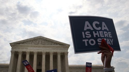 In this file image of the US Supreme Court building in 2016 a sign is held up that reads &quot;ACA Is Here To Stay&quot;after ruling was announced in favor of the Affordable Care Act. June 25, 2015 in Washington, DC. The Supreme Court refused Tuesday, January 21, 2020 to take up another challenge to the Affordable Care Act, leaving the health care law known as Obamacare intact.  (Mark Wilson/Getty Images)